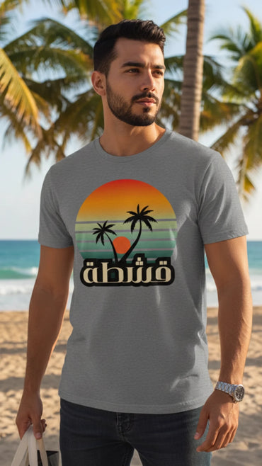 Man wearing the Retro Eshta Arabic sunset tee in Ice Grey on the beach, by Cairo NYC