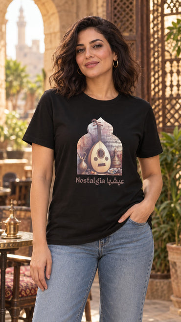 Woman in a black Nostalgia عيشها oud Arabic tee and light jeans in an Old Cairo courtyard