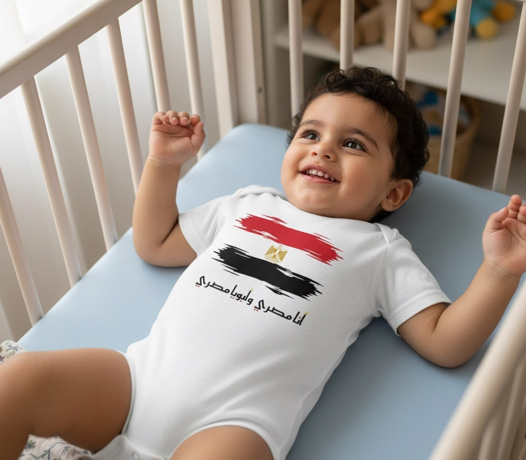 Smiling baby in a white Egypt flag أنا مصري وأبويا مصري Arabic onesie lying in a crib