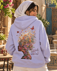Woman wearing the Ishtiry Dimaghek اشتري دماغك floral head hoodie in Orchid in a sunny courtyard, by Cairo NYC